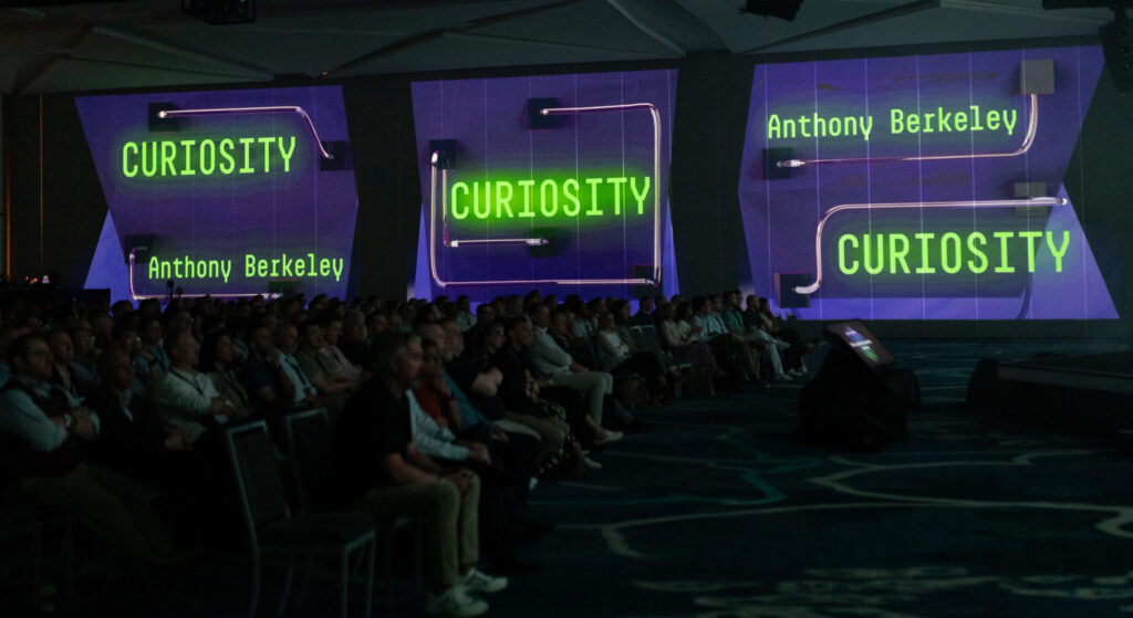 Dark room with the words Curiosity projected onto the walls