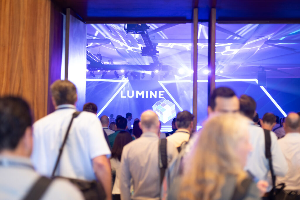 Crowd entering doorway with Lumine logo