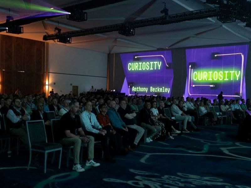 Words projected on a wall at a large conference.